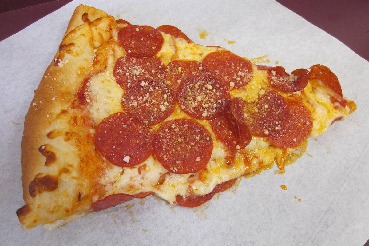 Slice of pepperoni pizza on a paper plate